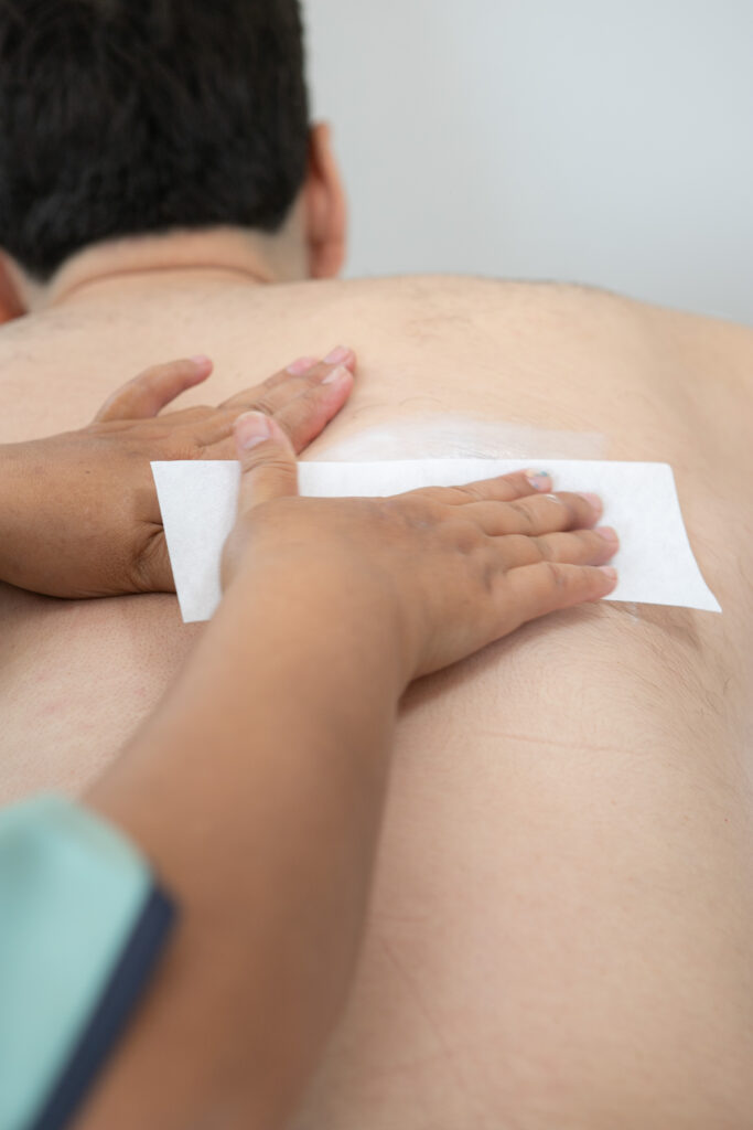 Back waxing strip removed by a therapist at Bangkok Glow